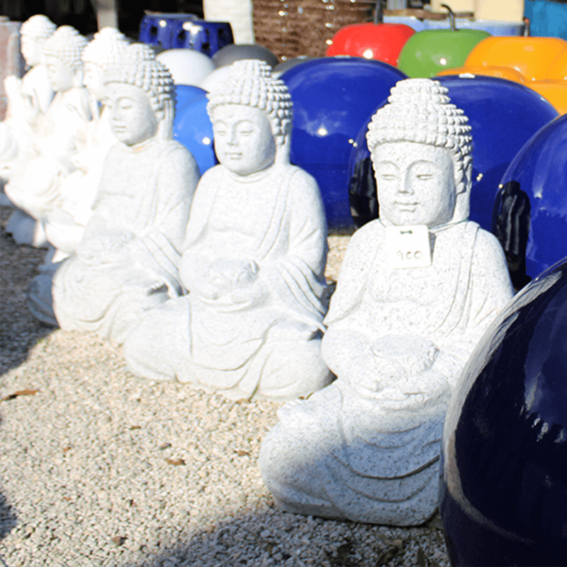 Stone Buddha statues colorful garden pots for sale in a plant nursery