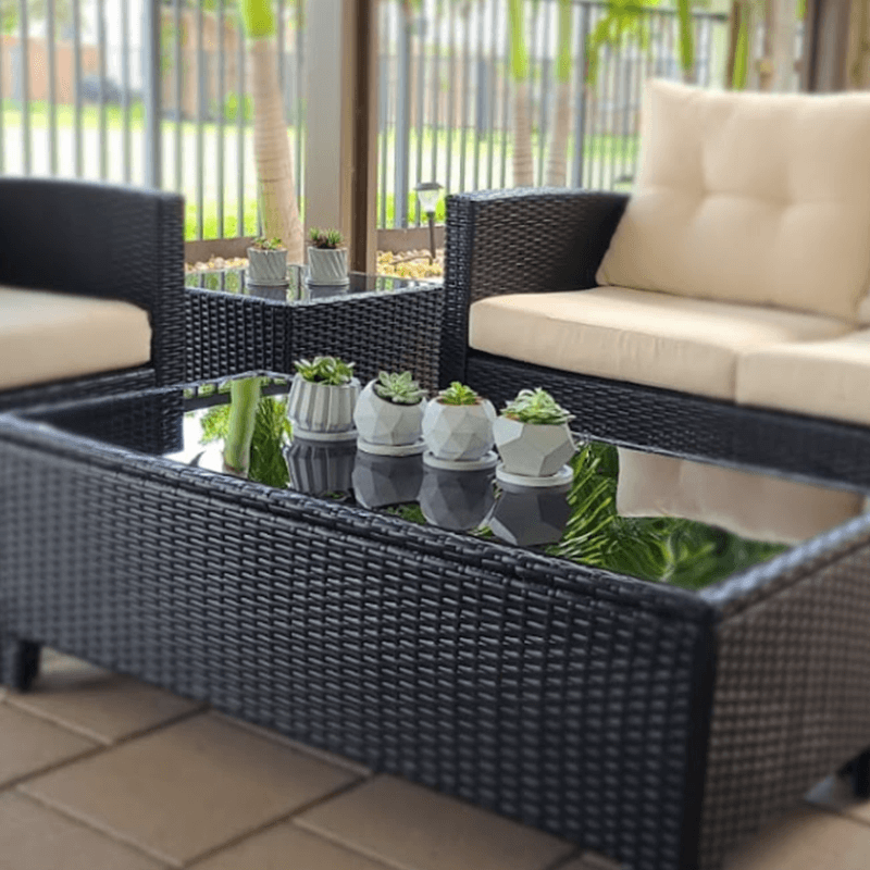 Cozy patio furniture with succulents in modern pots on a screened porch.